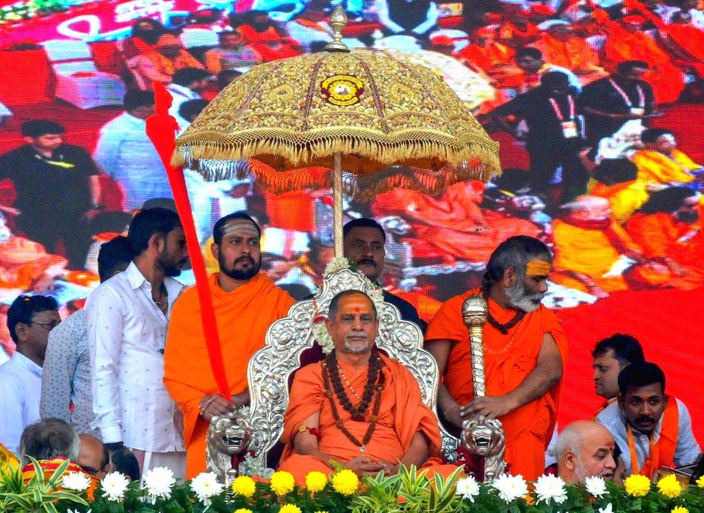 The Shankaracharya on a silver throne beneath a gold-embroidered parasol, attended by sannyasis holding a silver staff